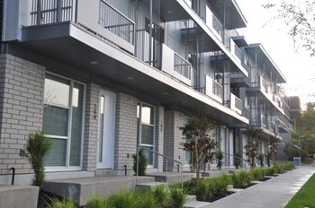 A modern apartment building with balconies and doors.